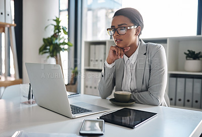 Buy stock photo Cropped shot of an attractive young businesswoman working on a laptop inside her office