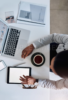 Buy stock photo High angle shot of a young businesswoman using a laptop and digital tablet while working in her office