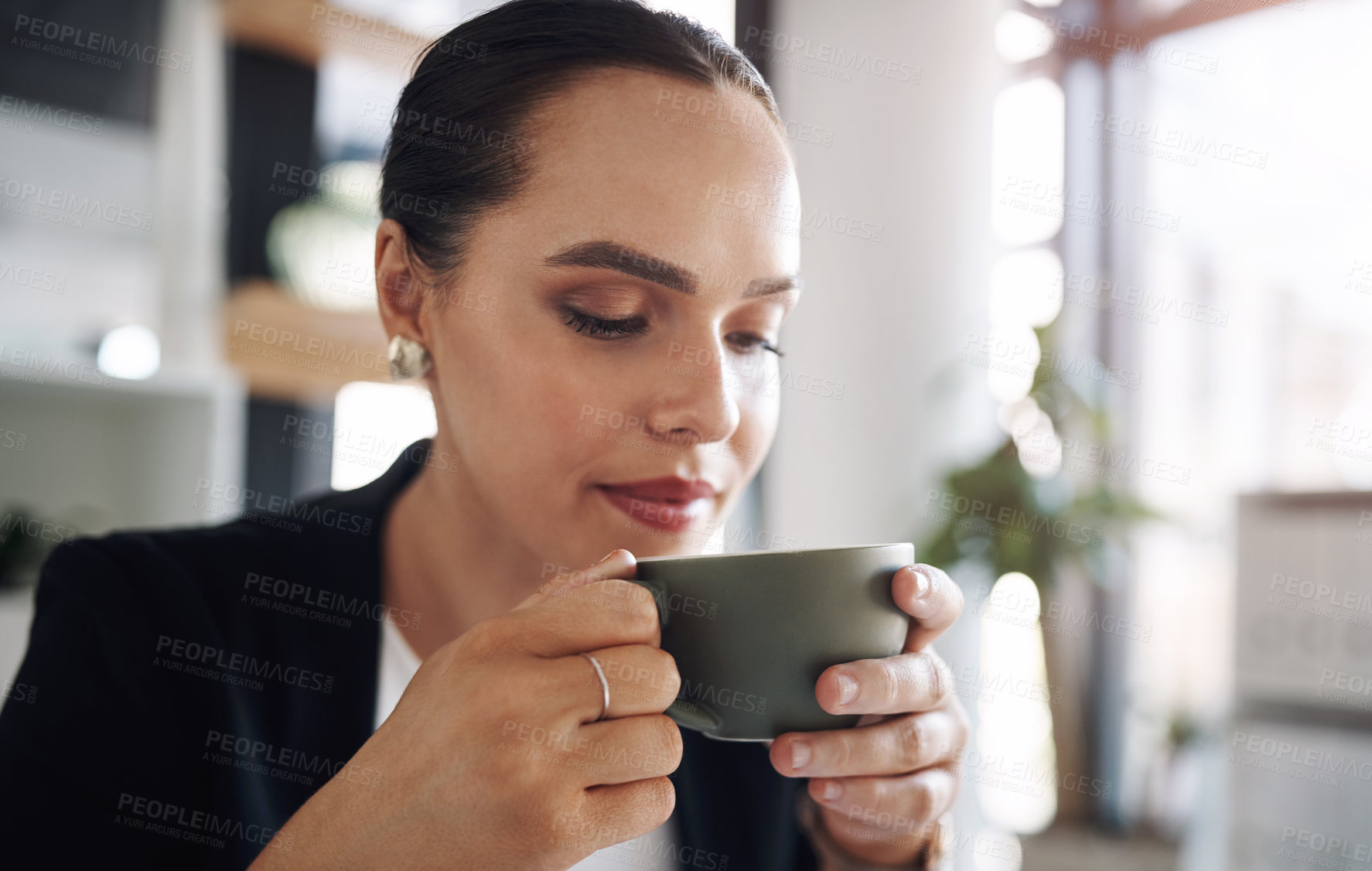 Buy stock photo Cropped shot of an attractive young businesswoman drinking coffee inside her office