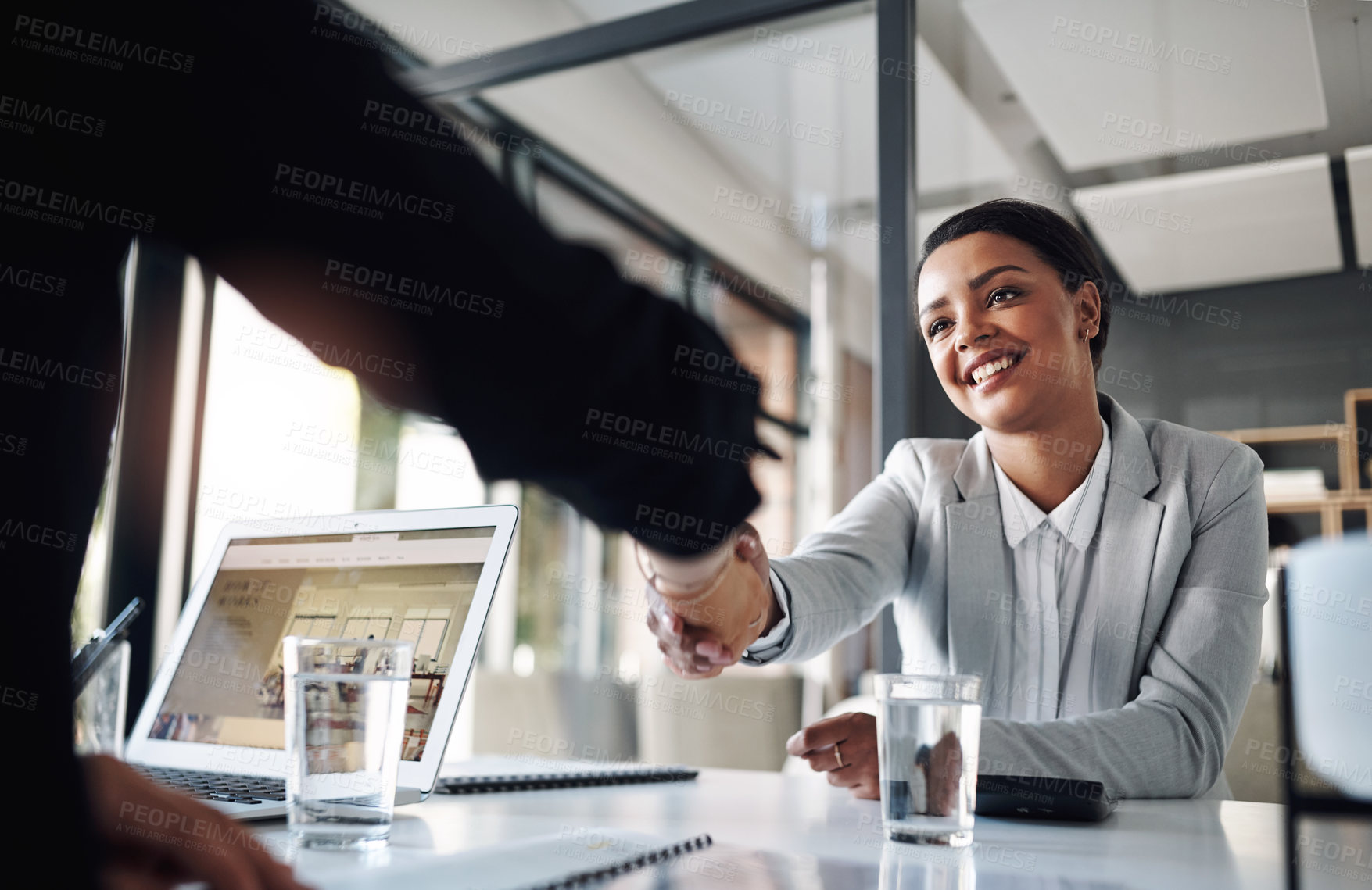 Buy stock photo Cropped shot of an attractive young businesswoman shaking hands with a colleague inside an office