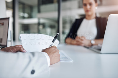 Buy stock photo Cropped shot of an unrecognizable filling out paperwork inside an office