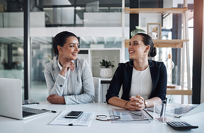 Buy stock photo Cropped shot of two attractive young businesswomen working together inside a modern office