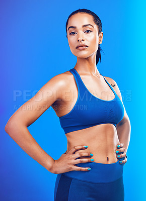 Buy stock photo Studio shot of an attractive young sportswoman posing against a blue background