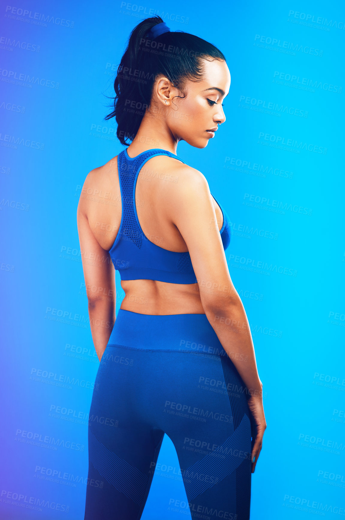 Buy stock photo Studio shot of an attractive young sportswoman posing against a blue background