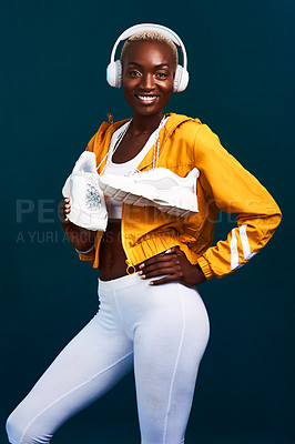 Buy stock photo Black woman, headphones and portrait with running shoes, workout and fitness playlist. Streaming, radio and happy from athlete training and wellness with internet song and joy with studio background