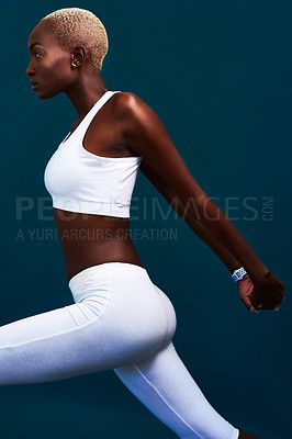 Buy stock photo Cropped shot of an attractive young sportswoman stretching against a dark background in the studio