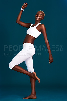 Buy stock photo Full length shot of an attractive young sportswoman feeling playful against a dark background in the studio