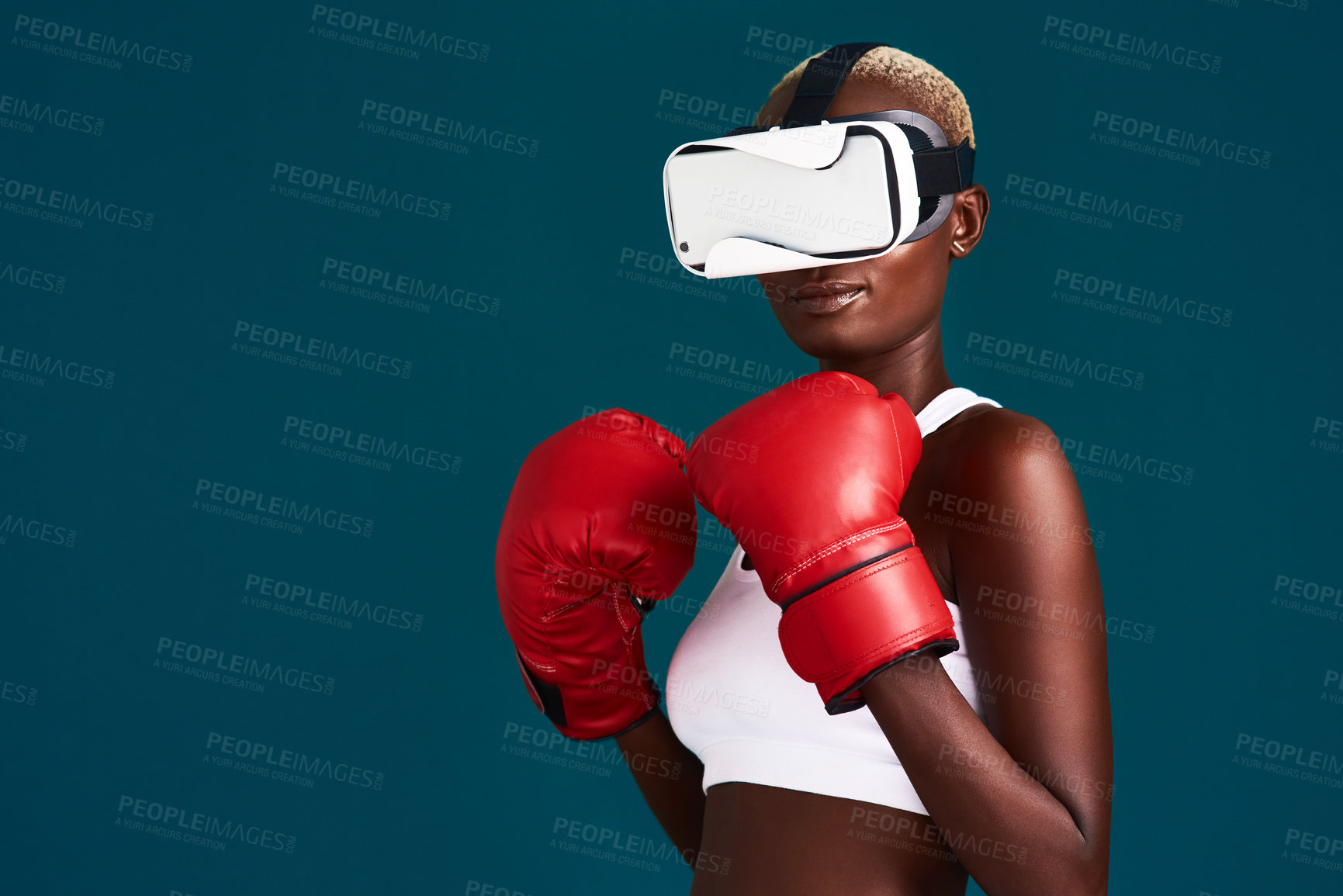Buy stock photo Cropped shot of an attractive young female boxer standing alone and using a vr headset while boxing