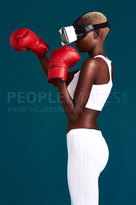 Buy stock photo Cropped shot of an attractive young female boxer standing alone and using a vr headset while boxing