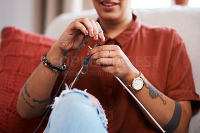 Buy stock photo Cropped shot of a young woman knitting while relaxing at home