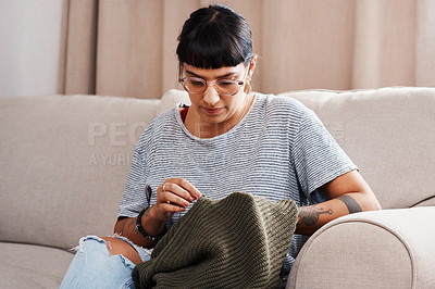 Buy stock photo Shot of a beautiful young woman doing needlework at home