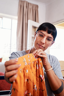 Buy stock photo Shot of a beautiful young woman working on a garment at home