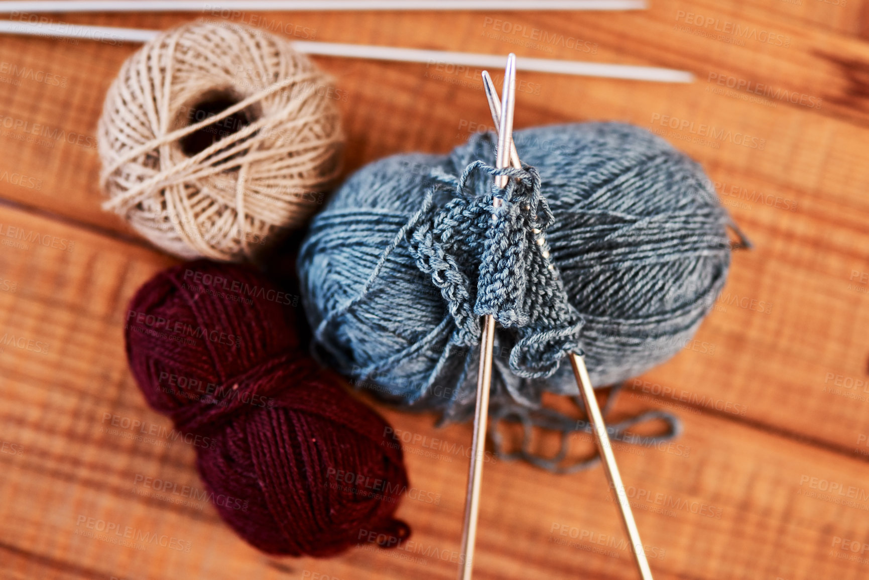 Buy stock photo Still life shot of multi colored woolen balls and knitting pens on a wooden table