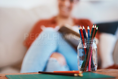 Buy stock photo Defocused shot of a woman using coloring pencils in a jar