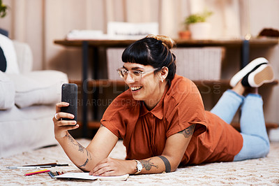 Buy stock photo Shot of a young woman taking a selfie while drawing at home