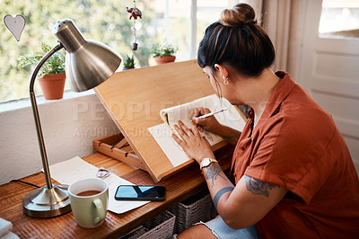Buy stock photo Cropped shot of a young woman sketching at home