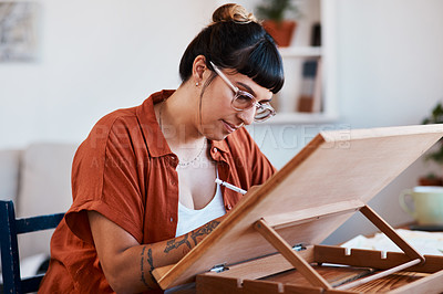 Buy stock photo Shot of an artist sketching in a desk easel at home