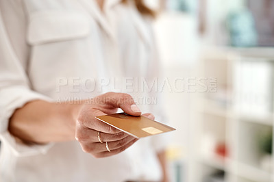 Buy stock photo Cropped shot of an unrecognizable businesswoman holding her credit card inside an office