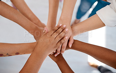 Buy stock photo Cropped shot of a group of unrecognizable businesspeople joining hands together in a huddle inside an office