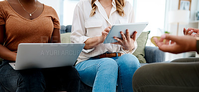 Buy stock photo Closeup shot of two unrecognisable businesswomen using a laptop and digital tablet during a meeting in an office