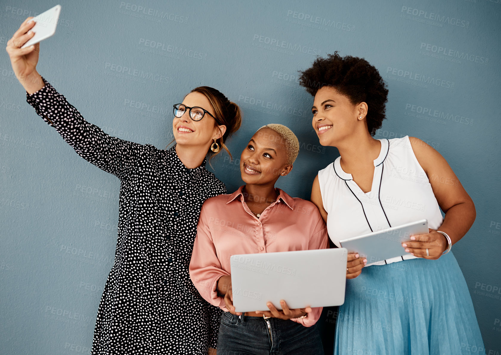 Buy stock photo Studio shot of a group of attractive young businesswomen taking a selfie together while standing against a grey background