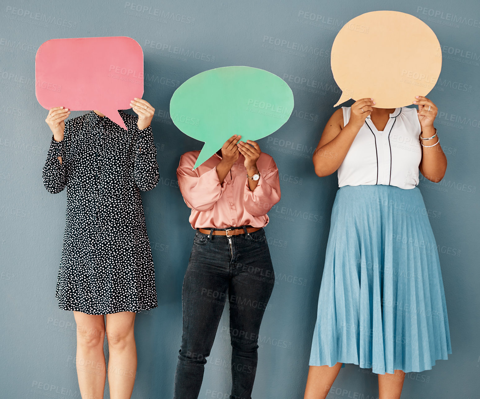 Buy stock photo Studio shot of a group of unrecognizable businesswomen covering their faces with speech bubbles while standing against a grey background
