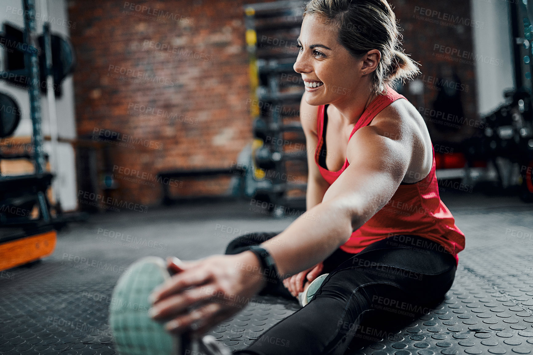 Buy stock photo Cropped shot of an attractive young female athlete stretching before starting her workout in the gym