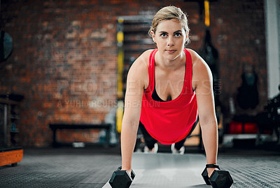 Buy stock photo Full length shot of an attractive young female athlete working out with dumbbells in the gym