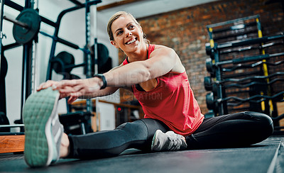 Buy stock photo Full length shot of an attractive young female athlete stretching before starting her workout in the gym