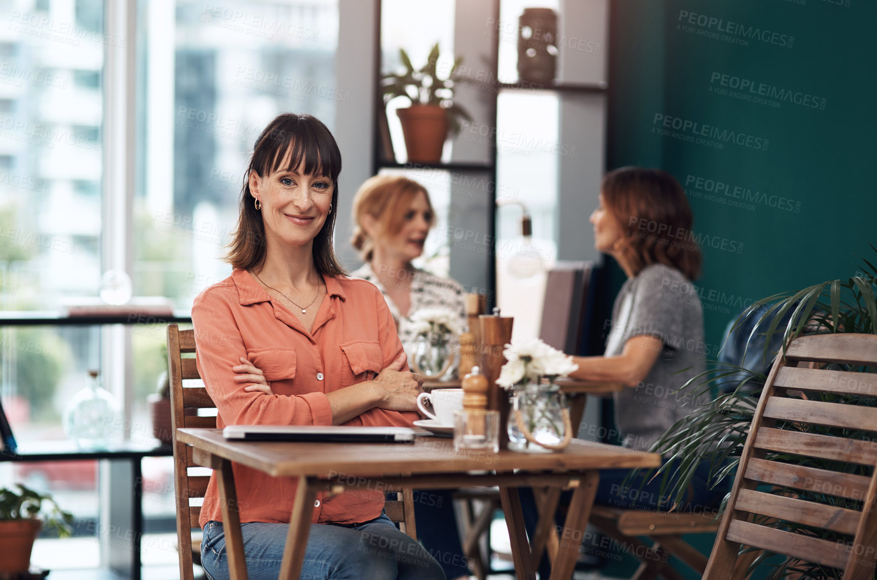 Buy stock photo Portrait of an attractive middle aged woman having coffee by herself at a coffee shop during the day