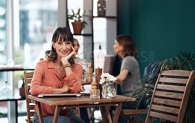 Buy stock photo Portrait of an attractive middle aged woman having coffee by herself at a coffee shop during the day