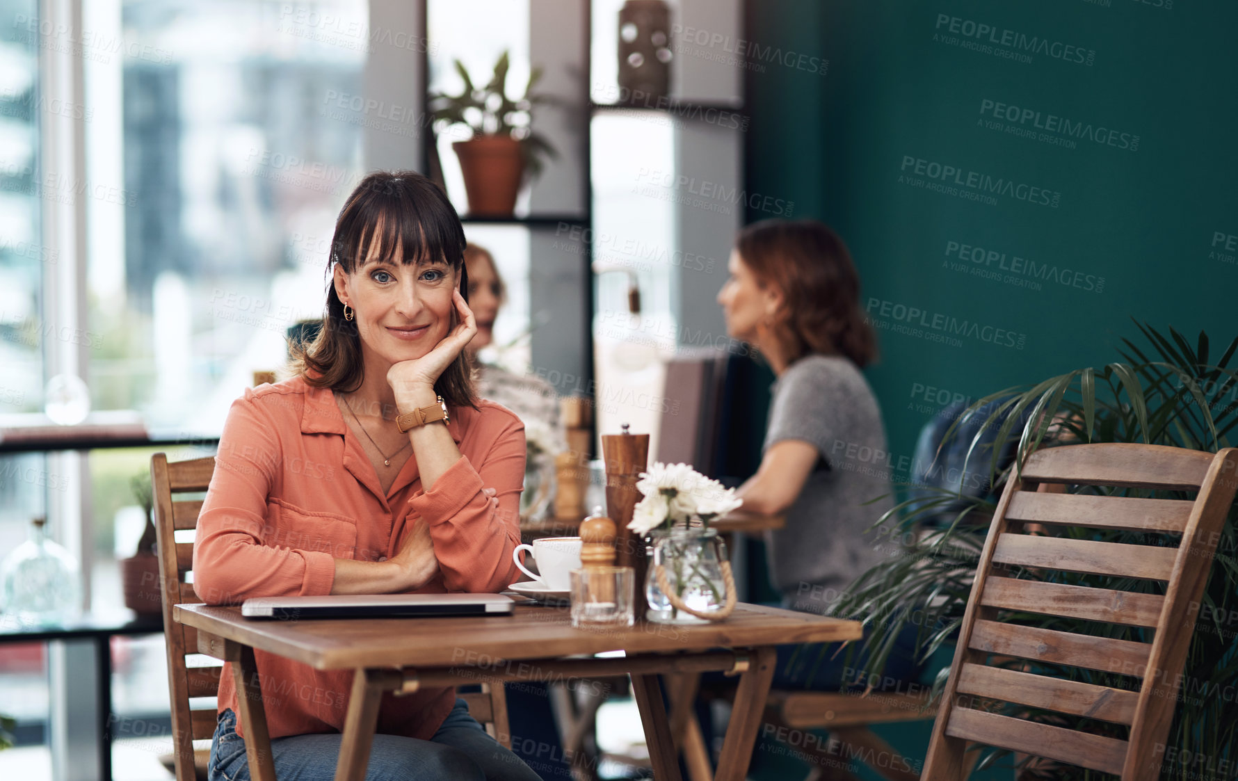 Buy stock photo Portrait of an attractive middle aged woman having coffee by herself at a coffee shop during the day