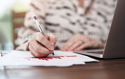 Buy stock photo Cropped shot of an unrecognisable woman making notes while working on her laptop inside of a coffee shop during the day