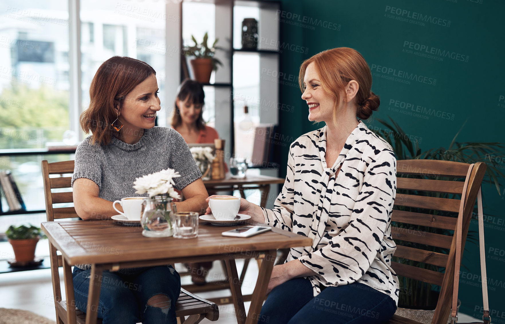Buy stock photo Cropped shot of two attractive middle aged women having a coffee date together as friends inside of a coffee shop during the day