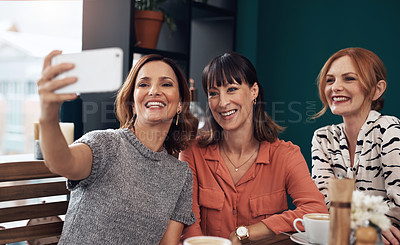 Buy stock photo Cropped shot of a group of attractive middle aged women taking a self portrait together while being seated inside of a coffee shop during the day