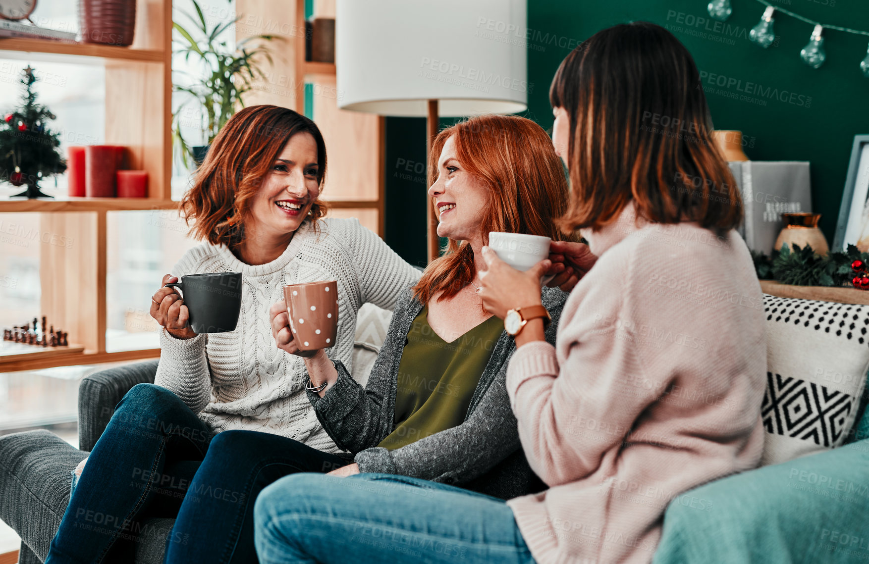Buy stock photo Cropped shot of three attractive  middle aged women having coffee together during Christmas eve at home