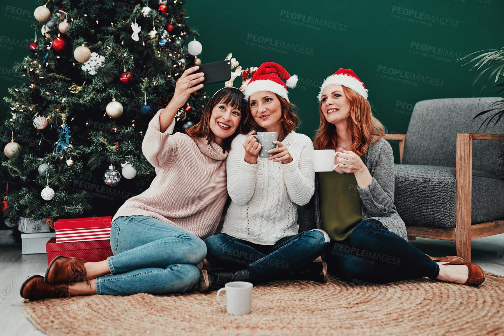 Buy stock photo Women, selfie and Christmas tree in living room for holiday, celebration and together with coffee. Technology, friends and group in home or apartment for relax, vacation and drink on floor in lounge