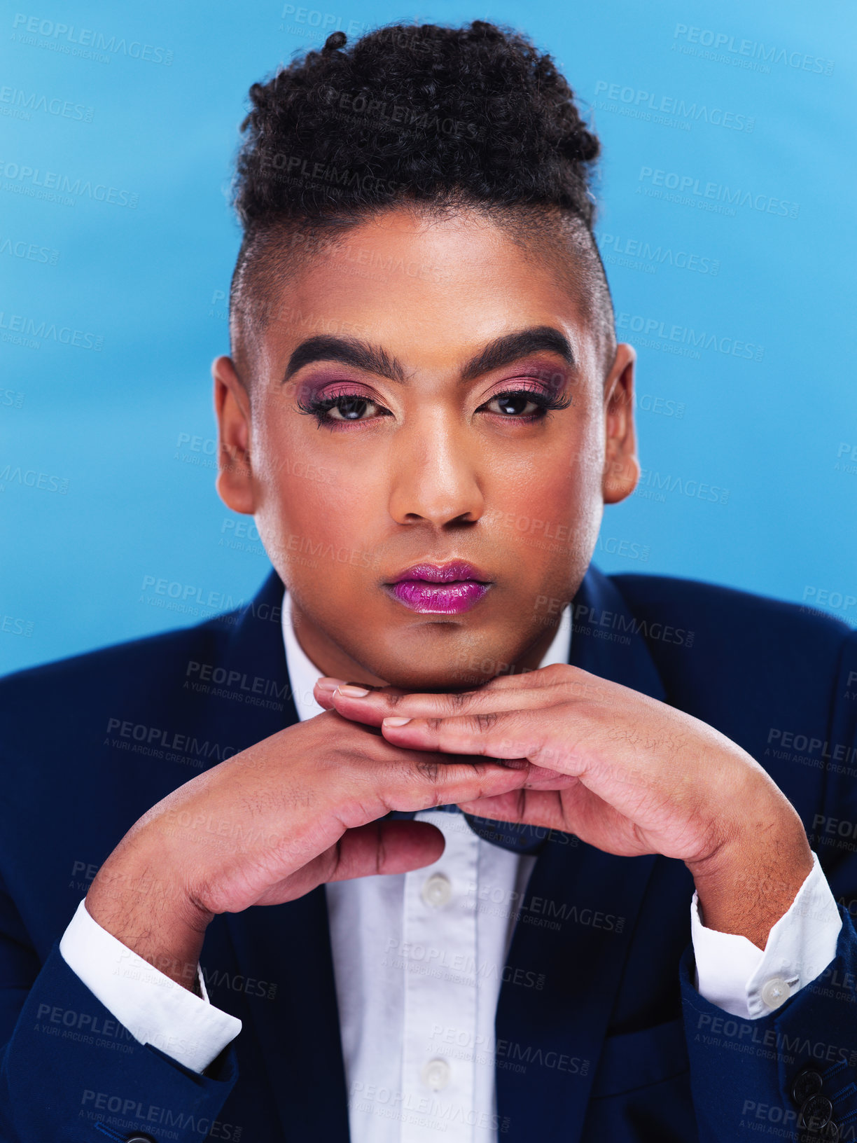 Buy stock photo Portrait of a gender fluid young businessman posing against a blue background