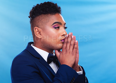 Buy stock photo Gay man, fashion and thinking in studio with daydream, vision and memory in formal style by blue background. Queer person, lgbtq model and ideas in suit, trendy and elegant clothes with makeup