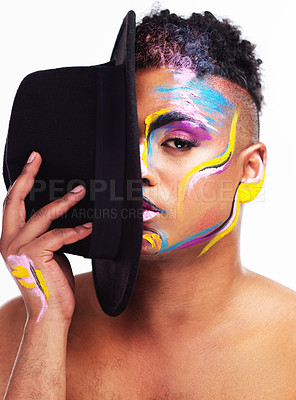Buy stock photo Portrait of a gender fluid young man wearing face paint and a hat posing against a white background