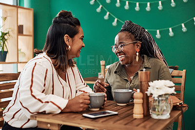 Buy stock photo Shot of two young women chatting at a cafe
