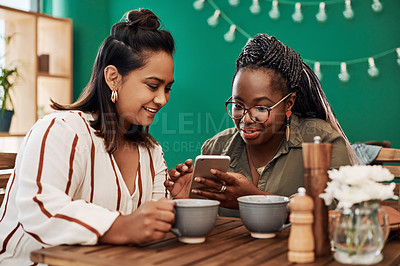 Buy stock photo Women, friends and happy with phone in coffee shop with listening, meme and bonding with reunion. People, talking and smartphone with tea cup, drinks or smile for care, social media and relax in cafe