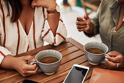 Buy stock photo Cropped shot of two women chatting and having coffee at a cafe