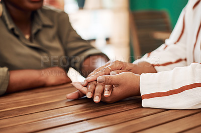 Buy stock photo Cropped shot of two unrecognisable women holding hands at cafe table