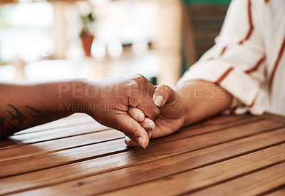 Buy stock photo Cropped shot of two unrecognisable women holding hands at cafe table