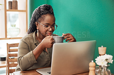 Buy stock photo Shot of a young woman having coffee and using a laptop at a cafe