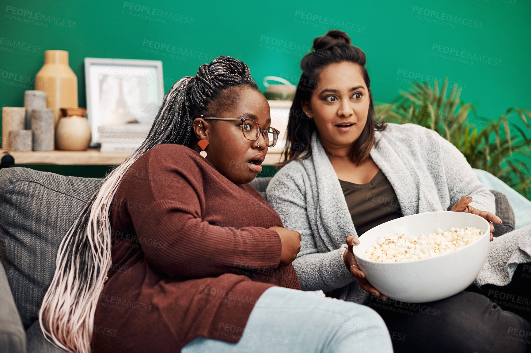 Buy stock photo Girl friends, scary movie and home living room surprised on a couch with fear and shock. Series, tv and women together in a lounge with a female friend looking at a television in house with popcorn