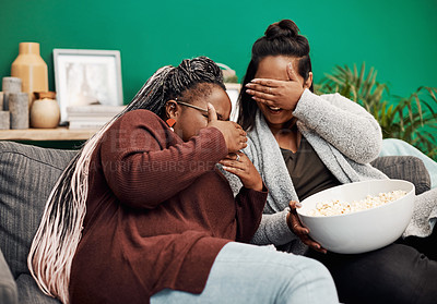 Buy stock photo Woman, friends and eyes closed with popcorn on sofa for streaming horror movie, thriller and spooky entertainment. Female people, home and scared with hands covering for intense film and frightened.