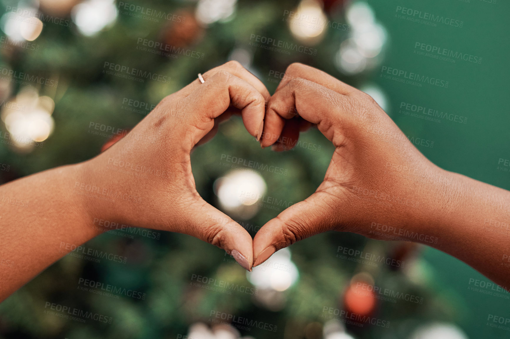 Buy stock photo Cropped shot of two women making a heart shaped gesture with their hands at Christmas