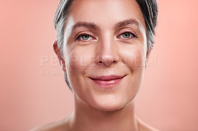 Buy stock photo Studio portrait of a beautiful mature woman posing against a peach background